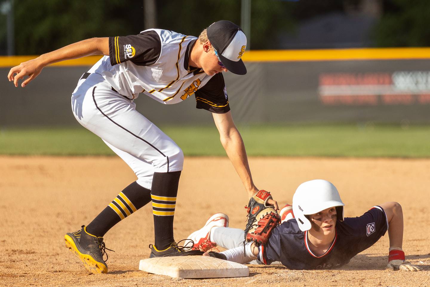 Trent Schinkey of Illinois District 20 looks up as Bryan Degen of Iowa attempts to tag him out on Saturday, July 12, 2025 at Washington Park in Peru.