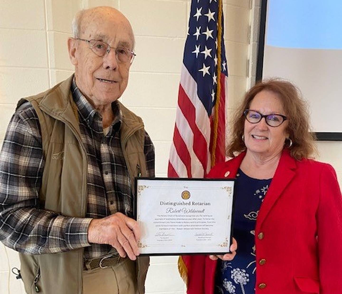 (Left to right); Rotary Club of Sycamore member Bob Wildenradt receiving his “Robert Wildenradt Fellows Society” certificate for perfect attendance from former club president Paulette Renault.