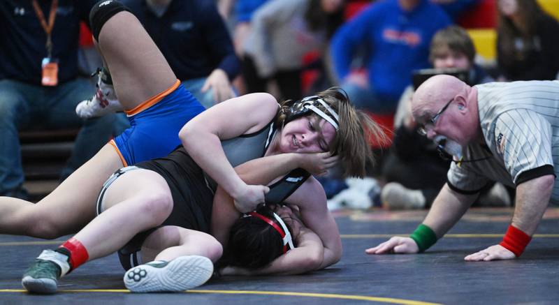 Oswego East’s Quinn Janssens, top, wins the 140-pound final against Hoffman Estates’ Abigail Ji during the Schaumburg girls wrestling sectional Saturday.