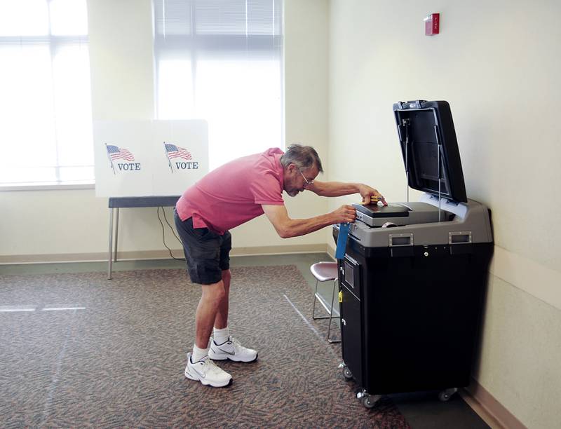 Election Judge Steve Krause opens up the voting machines Friday, June 24, 2022, at the McHenry County Administration Building, 667 Ware Road in Woodstock. Polls are open from 6 a.m until 7 p.m. today for people to cast their ballot in the in the primary election.