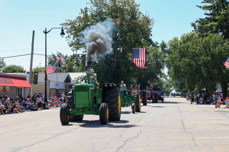 A tractor driver releases a cloud of smoke as he travels down Main Street during the 104th annual Herscher Labor Day Celebration Grand Parade on Monday, Sept. 1, 2025.