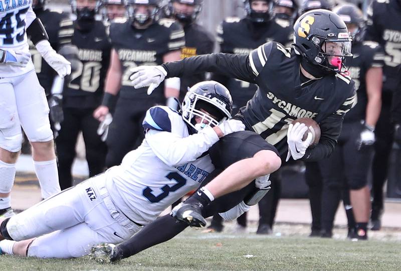 Sycamore's Burke Gautcher tries to pull away from Nazareth's Jaden Fauske late in the fourth quarter Saturday, Nov. 18, 2022, during their state semifinal game at Sycamore High School.