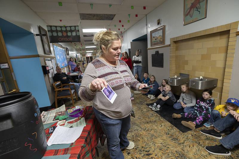 Open Sesame teacher Billie Jo Laidig shows off pictures pulled from the capsule, Monday, Dec. 23, 2024.