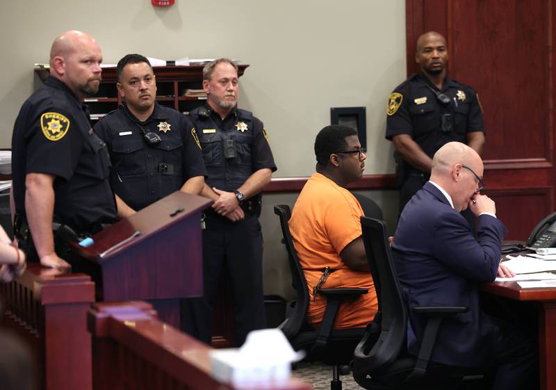 A group of DeKalb County Sheriff’s deputies stand behind Timothy Doll, who pleaded guilty to murdering DeKalb High School freshman Gracie Sasso-Cleveland in 2023, and his attorney Andrew Nickel, Thursday, Aug. 14, 2025, during his sentencing hearing at the DeKalb County Courthouse in Sycamore. Doll was sentenced to 52 years in prison.