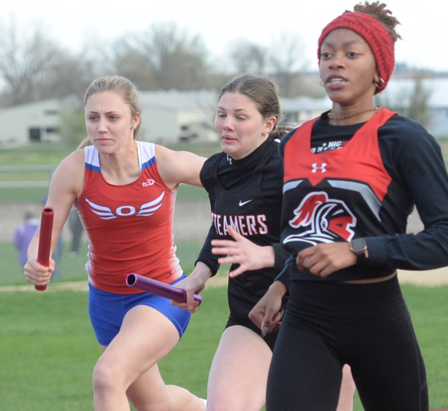 Oregon's Hadley Lutz (left) and Fulton's Miraya Pessman (center) chase after Rockford Auburn following the last hand off in the  4x100 at the Landers-Loomis Girls Invitational in Oregon on Friday, April 21.