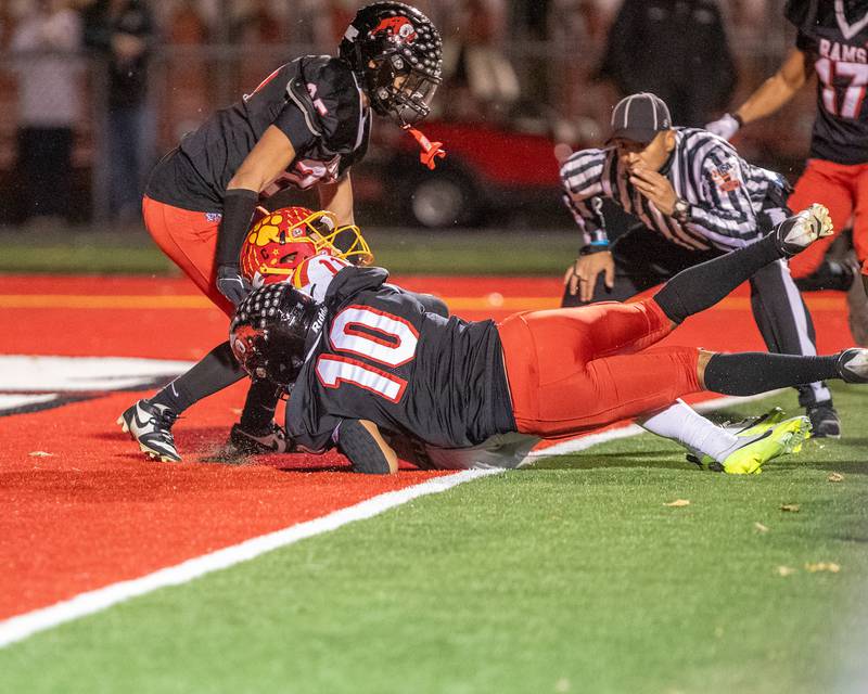 Batavia's Brett Berggren scores a touchdown as Glenbard East's David Salgado tries for the tackle at the Class 7 A Second Round playoff game on Friday, Nov. 7,2025 in Lombard.
