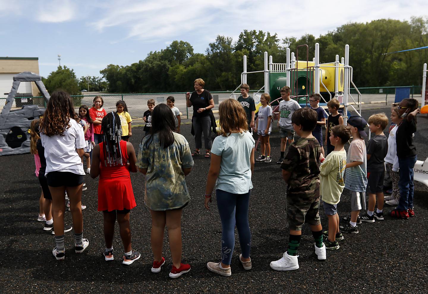 Teacher Amy Blazier teaches students a game on the playground Thursday, July 28, 2022, at the Friendship House, 100 South Main Street, in Crystal Lake. Childcare centers are struggling to find enough teachers to maintain operations.