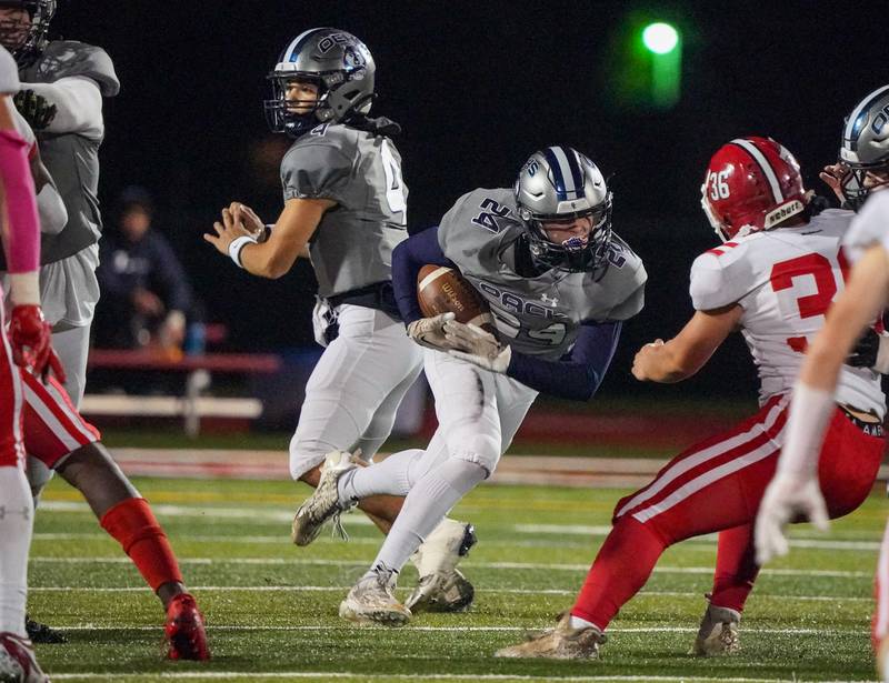 Oswego East's Christian Martyn (24) carries the ball against Yorkville during a football game at Yorkville High School on Friday, Oct. 13, 2023.