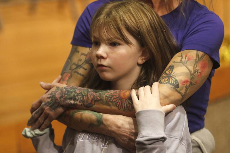 Brooklyn Larson of Harrison Elementary snuggles into the arms of her mom, Amy, before the start of the McHenry County Regional Office of Education 2023 Spelling Bee Wednesday, March 22, 2023, at McHenry County College's Luecht Auditorium in Crystal Lake.