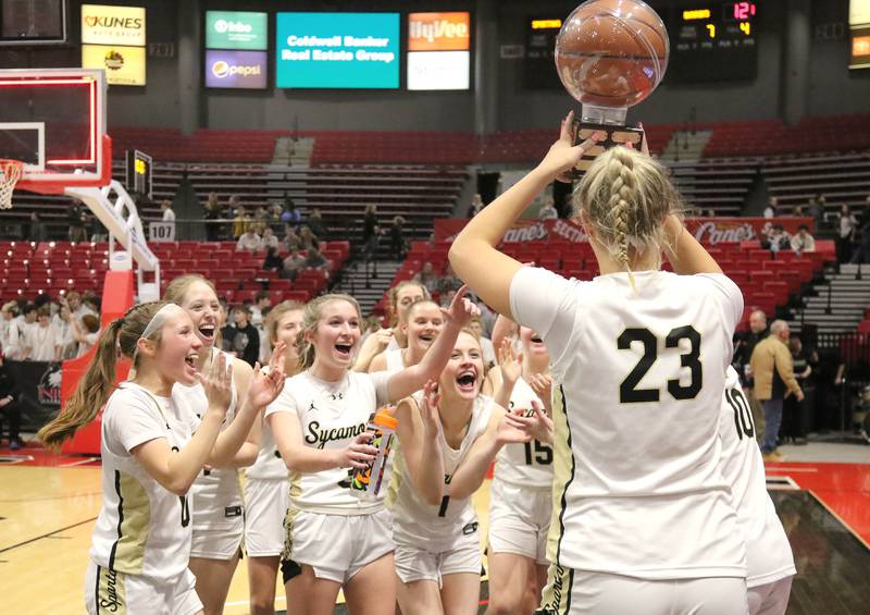 Sycamore's Evyn Carrier brings the trophy to her team after beating DeKalb in the girls game at the First National Challenge Friday, Jan. 27, 2023, at The Convocation Center on the campus of Northern Illinois University in DeKalb.