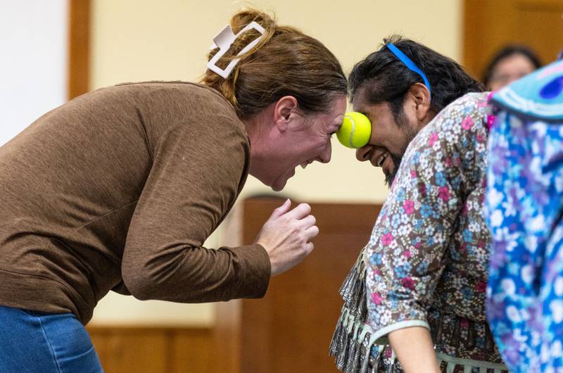 Katie Vidal, left, and Alfredo Vidal of Crystal Lake perform a traditional potato dance with a tennis ball during the Welcome Winter Celebration at the Lost Valley Visitor Center in Ringwood on Saturday, Dec. 28, 2024. The couple won the competition by being the remaining pair holding the ball between their heads.