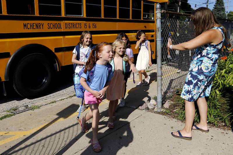 Esther Gamalski greets students as they get off the bus  the first day of school for McHenry's Landmark Elementary School on Wednesday, July 17, 2024.