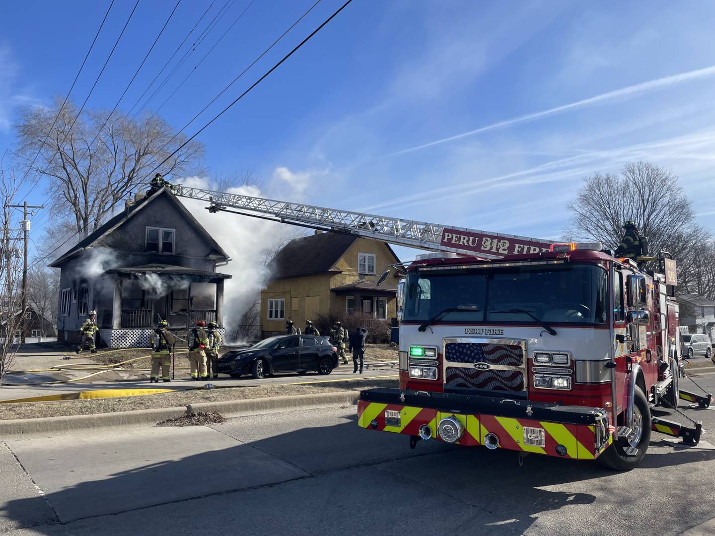 An aerial truck from the Peru Fire Department extends toward the roof of a burning structure Friday, Jan. 23, 2026, in La Salle, allowing firefighters to reach the seat of the fire and conduct roof operations.