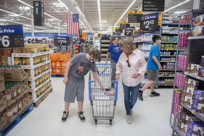 Jon Adams and para-professional Ann Warren place items into a cart during their trip through the store. The class was divided into four groups to shop for the recipe.