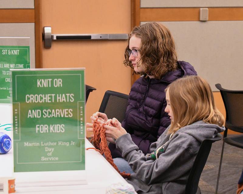 Molly Mathias, 9, and sister Jade Mathias, 14, of Elmhurst finger knit on Monday Jan. 20, 2025, held at the Elmhurst library during the Martin Luther King Jr. Day of Service.