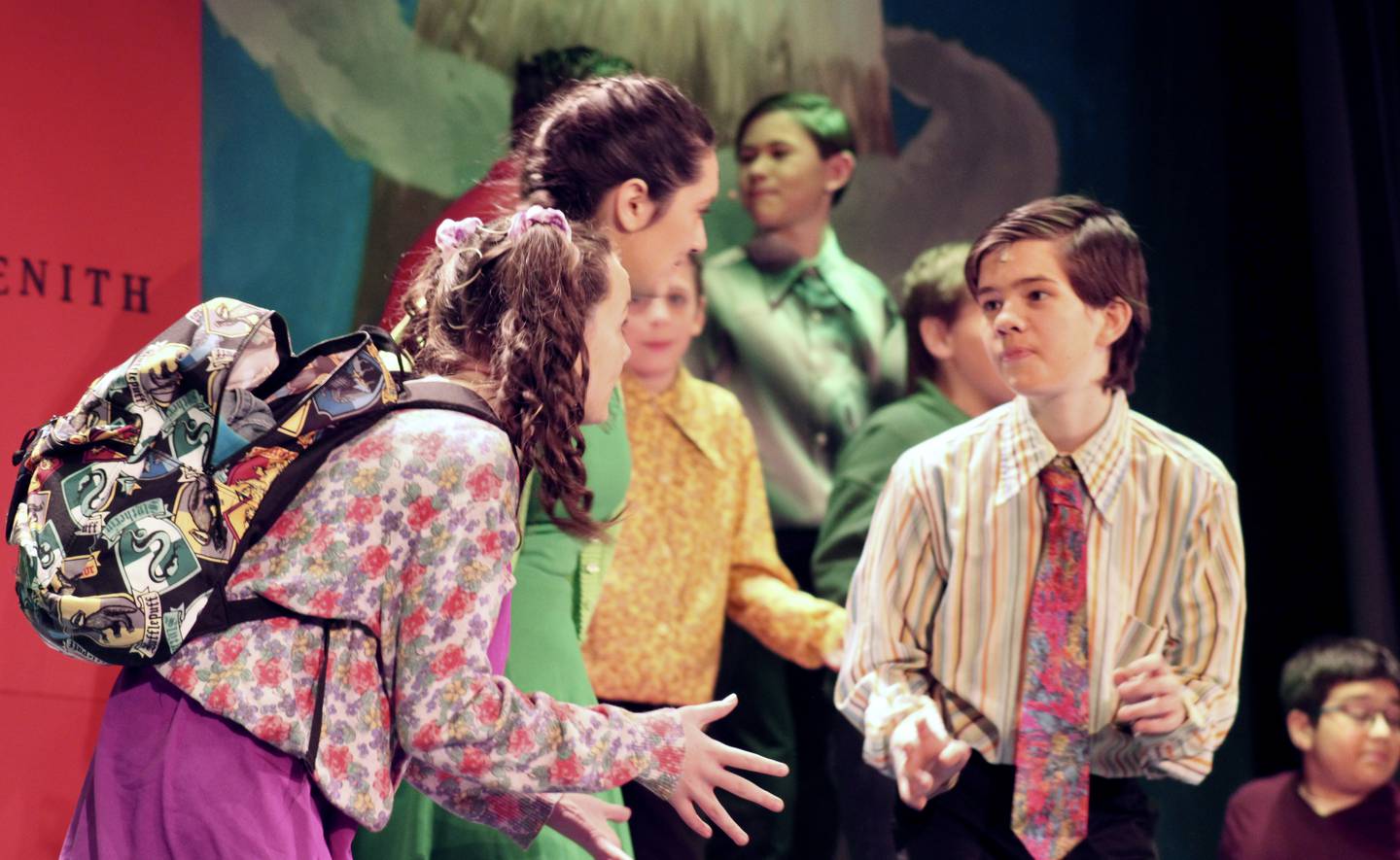 During the number "Unpack Your Adjectives," Kate Wadsworth as Shulie, Aly Krueger as Dina and Aaron Wadsworth as Tom Mizer share center stage during a production of "School House Rock! Live Jr." by Woodlawn Arts Academy and Dixon Public Schools.