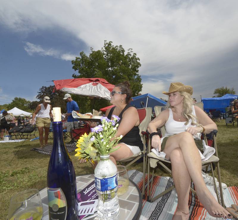Migdalia Bishop and Erica Hottinger have their table set as they enjoy the live music and wine during the Vintage Wine Festival Saturday at Carey Memorial Park in Utica.