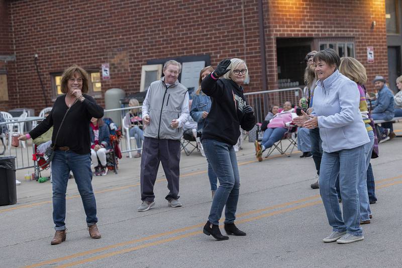 Friends from Dixon High School class of ’80, dance together Saturday, Sept. 6, 2025, at Dement Town Music Fest. The group was celebrating their 45th reunion at the festival.
