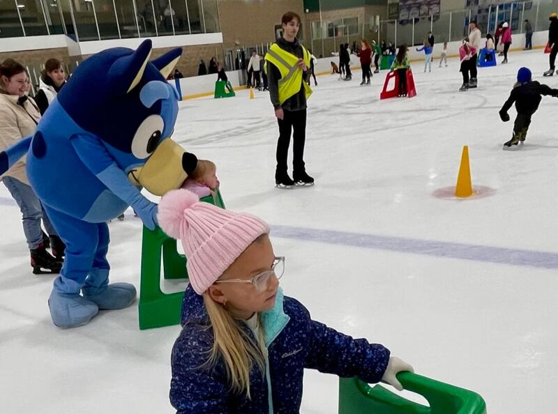 Scout Strysik, 6, of Bourbonnais, ice skates with a skate helper as cartoon favorite Bluey skates nearby on Saturday at Ice Valley Centre Ice Arena during Kankakee Valley Park District's annual Winter Fest.