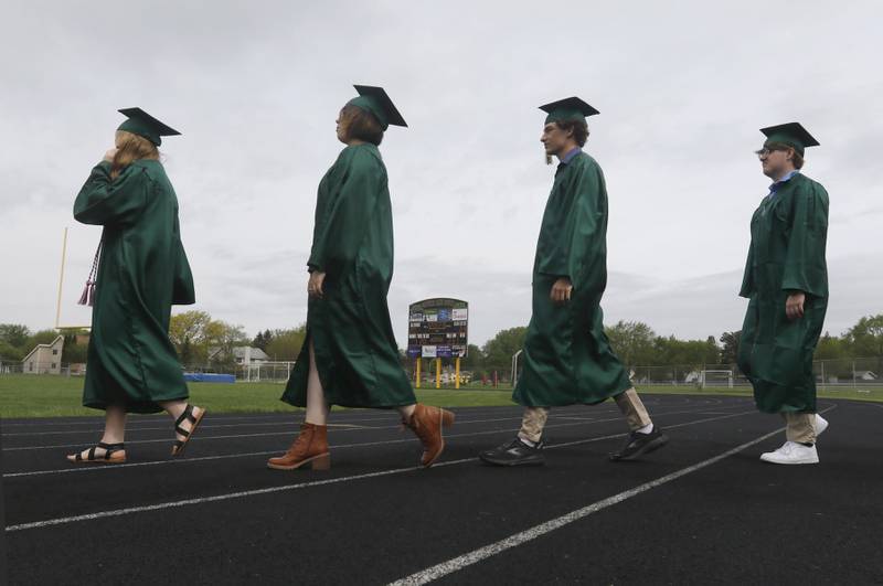 Graduates walk across the track to the football field Saturday, May 13, 2023, during the graduation ceremony for class of 2023 at Crystal Lake South High School in Crystal Lake.