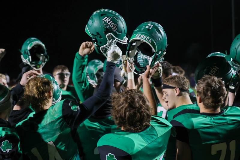 Seneca players hold up their helmets in celebration of their first-round Class 2A playoff win Friday, November 1, 2024, at Seneca High School.