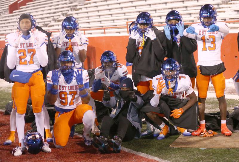 Members of the East St. Louis football team pose for a photo while warming up on the sidelines during the Class 6A State championship game on Tuesday, Dec. 2, 2025 in Hancock Stadium at Illinois State University in Normal.