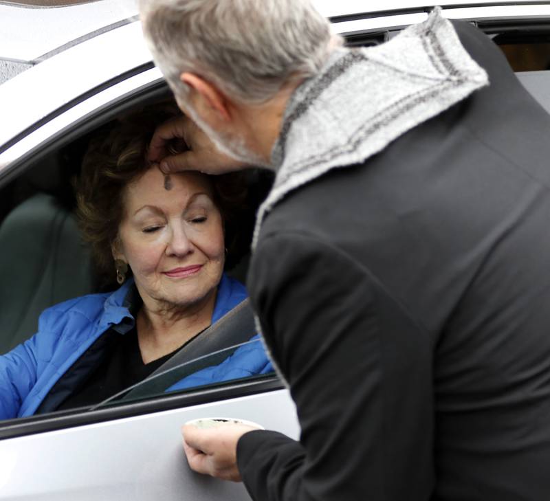Rev. Jeffry Bross, the senior pastor at the United Methodist Church of Libertyville, places ashes on Marilyn Schmitt’s forehead during a Drive-Thru Ash Wednesday Blessing on Wednesday, March 05, 2025, at the United Methodist Church of Libertyville. This was the first time the church has offered a Drive-Thru Ash Wednesday Blessing, that created a simple convenient way for individuals to receive ashes and mark the beginning of the Lenten season.