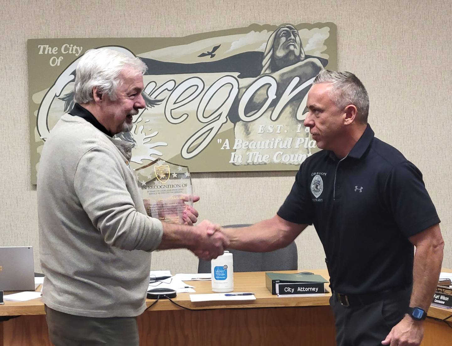 Oregon Mayor Ken Williams, left, congratulates outgoing Police Chief Shawn Melville. Lt. Joseph Brooks was sworn as Oregon's new chief of police on Sept. 27, and will become chief effective Oct. 3.