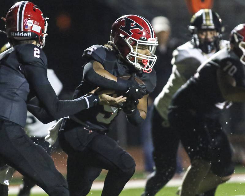 Yorkville's T.J. Harland (5) takes a handoff during Class 7A first round football game between Glenbard North at Yorkville. Friday, Oct 31, 2025 in Yorkville.