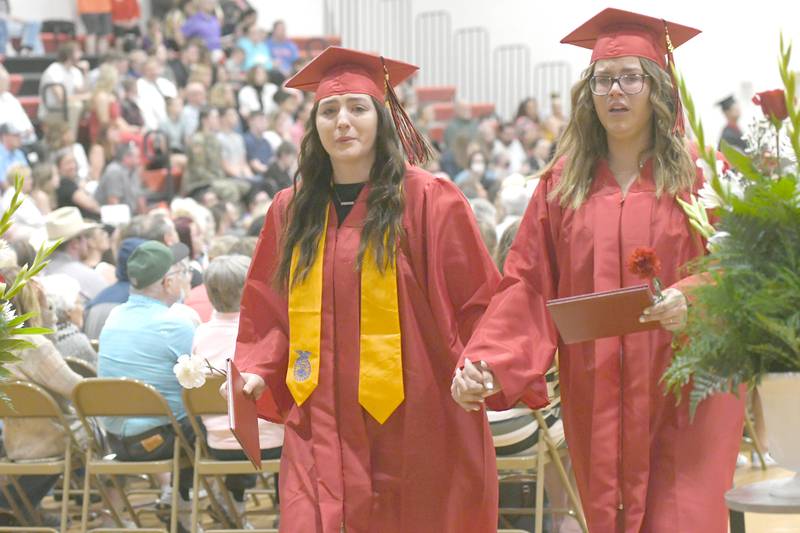 Laci Meyer and Courtney Greenfield become emotional as they exit the Forreston High School gym following commencement on Sunday.