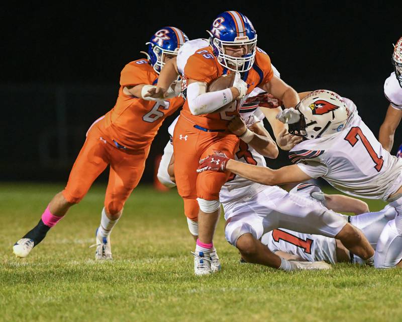 Genoa-Kingston's Luis Angel Espino Martinez, center, runs the ball for a first down being tackled on Friday Oct. 11, 2024, while taking on Stillman Valley held at Genoa-Kingston High School.