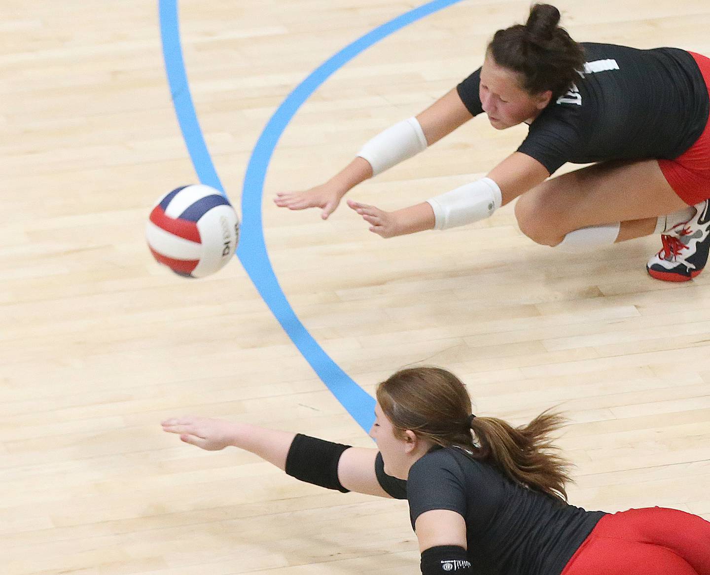 Hall's Haylie Pellegrini and Evey Meyer dive for the ball against Marquette on Monday, Sept. 25, 2023 at Bader Gym.