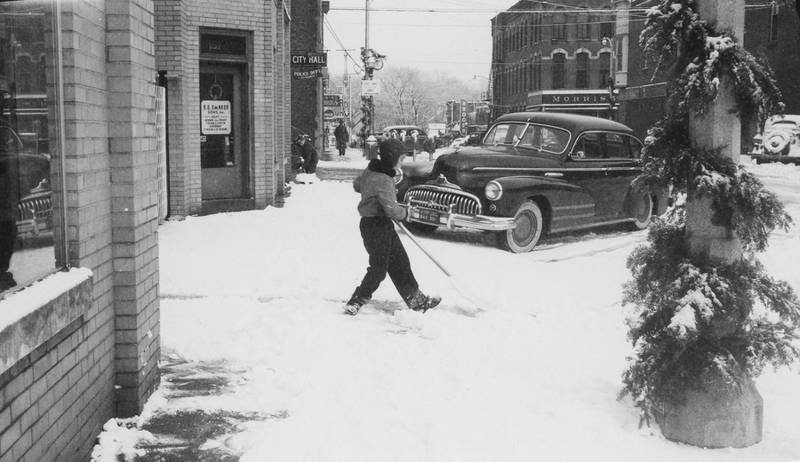 Two boys shoveling snow on South 2nd Street in DeKalb, looking north, December 1949.
