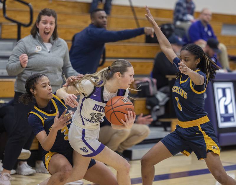 Dixon’s Morgan Hargrave works against Sterling’s Delali Amankwa (left) and Taah Liberty Tuesday, Feb. 13, 2024 during a regional semifinal at Rochelle.