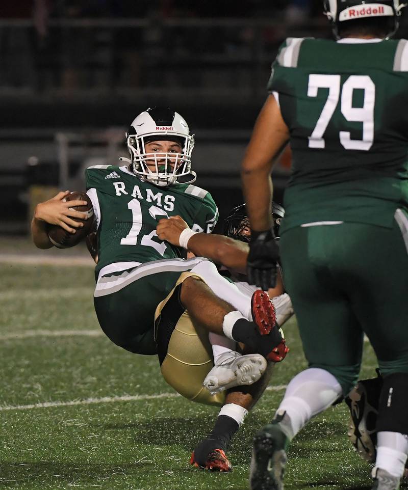 Grayslake Central quarterback Braden Carlson is tackled by Grayslake North’s Juan Marquez in a football game at Central High School on Thursday, September 14, 2023.