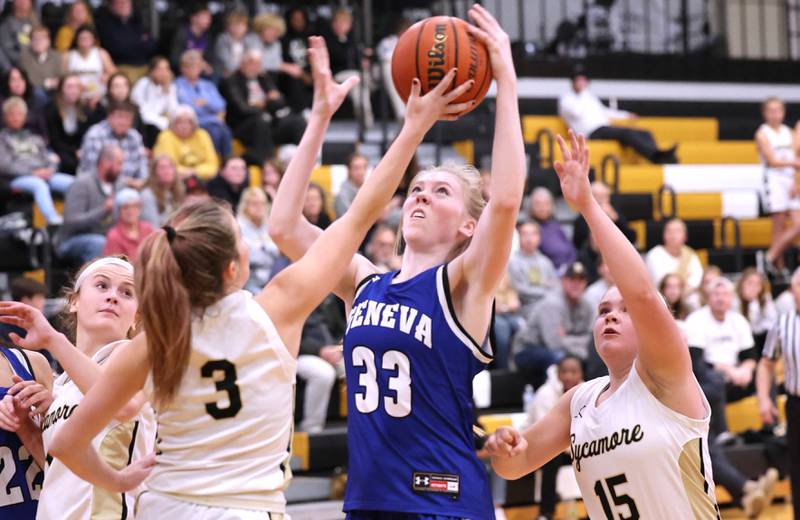 Geneva's Lauren Slagle grabs a rebound between Sycamore's Malerie Morey (left) and Sophia Klacik during their game Monday, Nov. 14, 2022, at Sycamore High School.