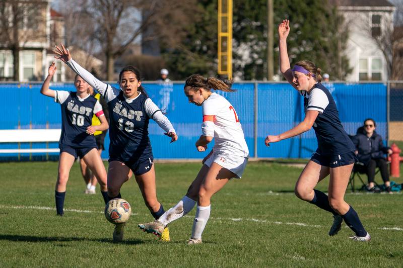 Oswego’s Anna Johnson (20) shoots the ball while Oswego East's players appeal for an offsides call during a soccer match at Oswego East High School on Thursday, Apr 6, 2023.