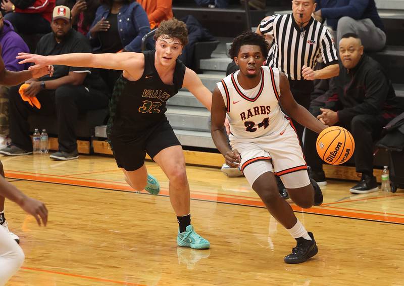 DeKalb's Myles Newman drives by Waubonsie Valley's Tyus Payne during their game Friday, Feb. 21, 2025, at DeKalb High School.
