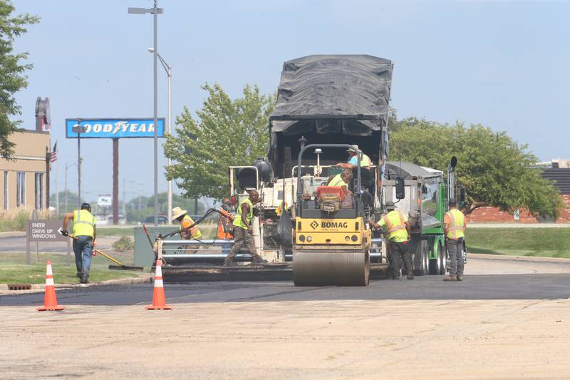 Workers with Advanced Asphalt pave the north entrance to the Peru Mall on Monday, July 17, 2023 in Peru. The project is on private property and is not city funded.