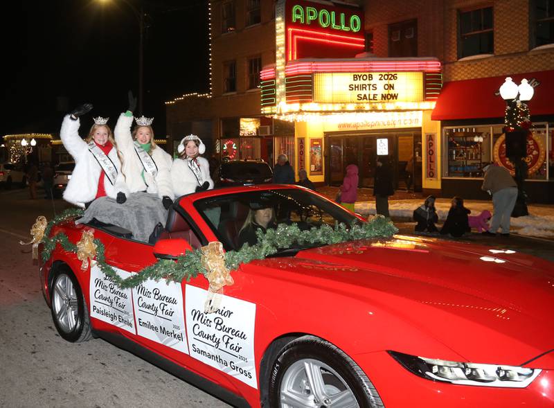 Bureau County Fair royalty Paisleight Ehnle, Emilee Merkel and Samantha Gross ride during the "Night of Lights" parade on Friday, Dec. 5, 2025 downtown Princeton. The event featured the Christmas tree lighting at Veterans Park a lighted Christmas parade down Main Street,  Living Windows, a Candy Cane Hunt, and visits with Santa.