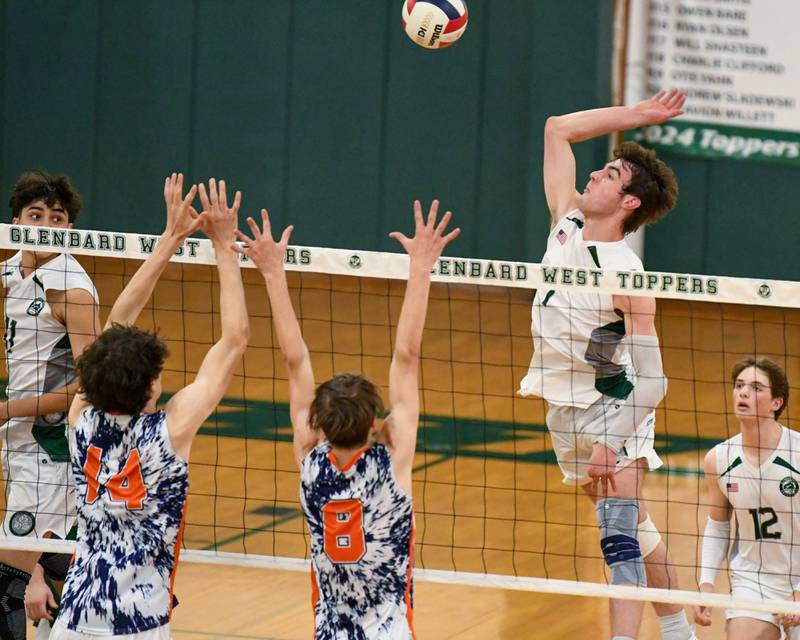 Glenbard West's Casey Maas (1) spikes the ball past Oak Park-River Forest's Roann Doody (14) and teammate Quinn Bozarth (8) during the game on Tuesday April 16, 2024, held at Glendbard West High School.