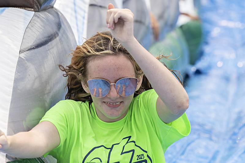Dixon Park District seasonal worker Madisyn Halfacre gets in on the fun by going down a water slide Thursday, June 15, 2023.
