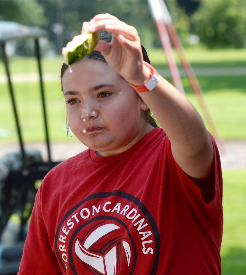 Natalie Brockmeier, 12, of Forreston, holds her watermelon rind high as she wins one of the kid divisions at Sauerkraut Days' watermelon-eating contest  in Forreston on Saturday, Aug. 2, 2025.