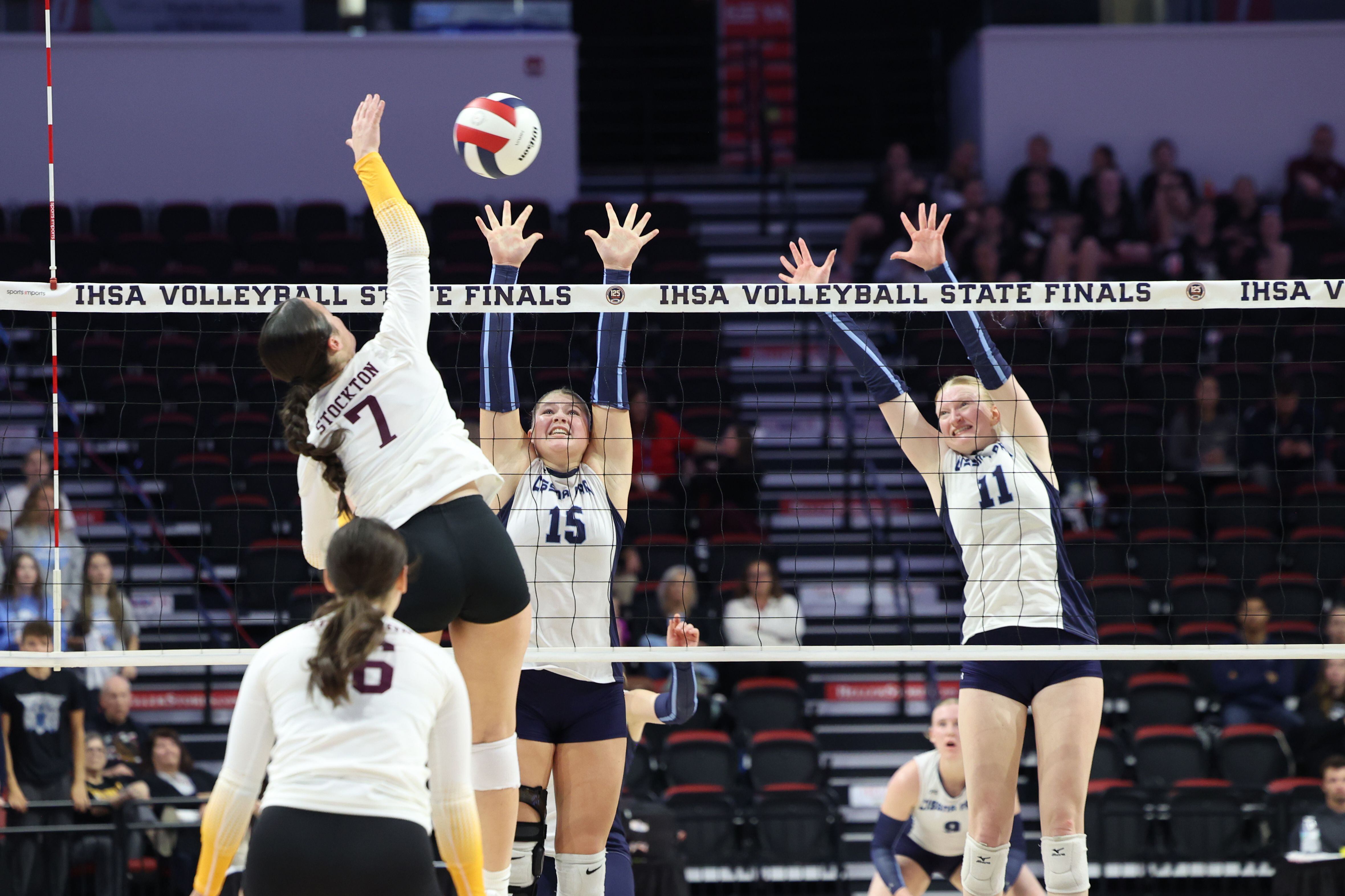 Cissna Park's Ava Henrichs, center, and Sophie Duis jump to block a hit during the Timberwolves' victory in two sets, 25-11, 25-14, over Stockton in the IHSA Class 1A State championship on Saturday, Nov. 15, 2025.