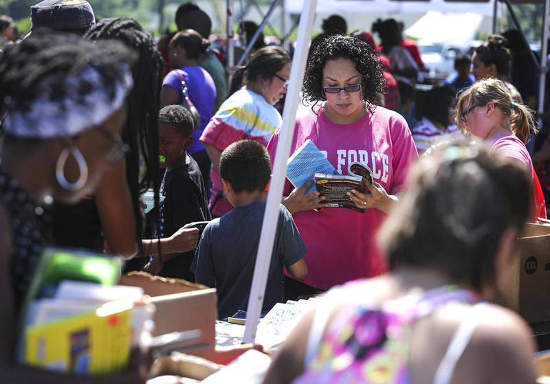 Families and students flip through boxes of books Thursday during Catholic Charities' annual Back to School Fair in Joliet.