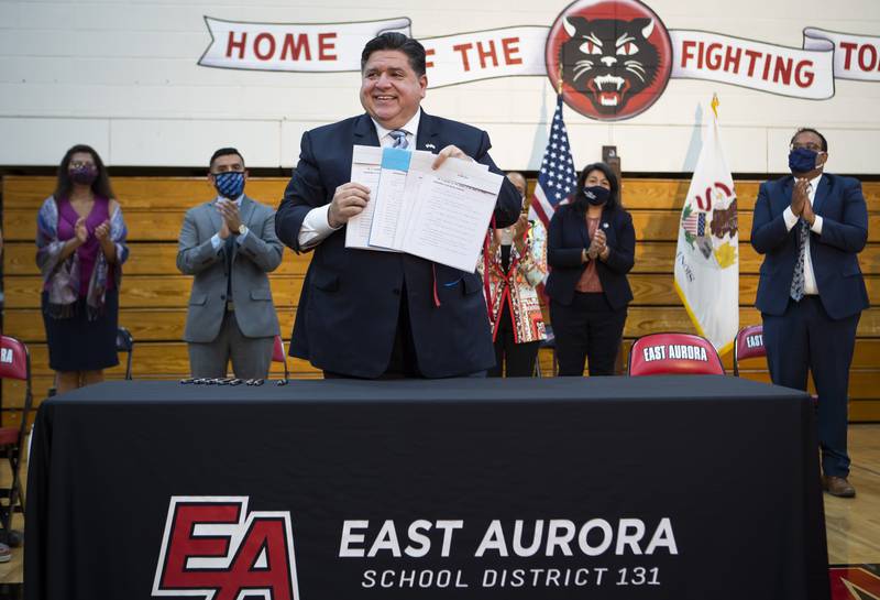 Illinois Gov. J.B. Pritzker smiles after signing legislation that expands protections for immigrant and refugee communities at East Aurora High School in Aurora, Ill. Monday, Aug. 2, 2021. (Rich Hein/Chicago Sun-Times via AP)