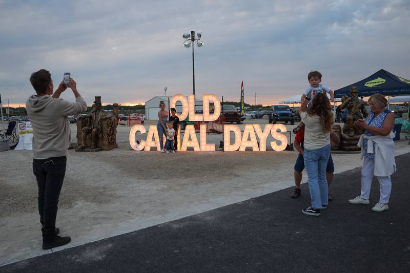 Families take turns getting photos at the Old Canal Days sign on Friday June 7, 2024 in Lockport.