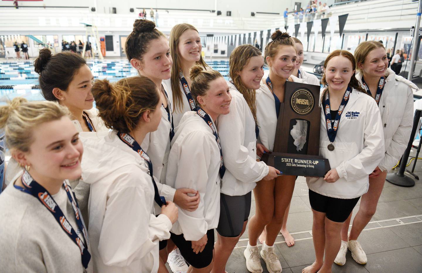 St. Charles North swimmers hold their state runner-up trophy at the conclusion of the girls state swimming and diving finals at the FMC Natatorium on Saturday, Nov. 15, 2025 in Westmont.