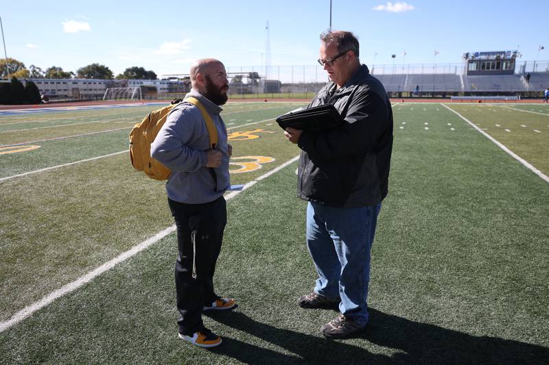 Herald-News reporter Ron Oesterle talks with Joliet West head coach Dan Tito after the Tigers win against Joliet Central on Saturday.