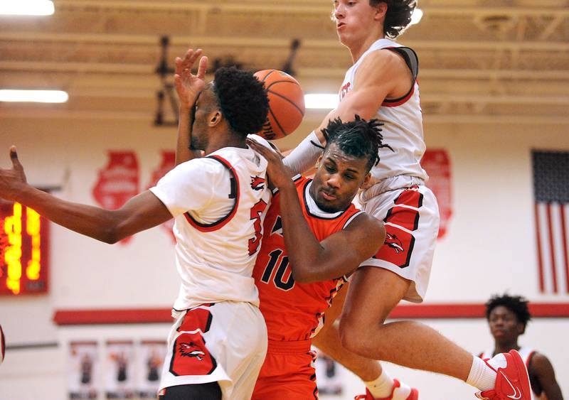 Romeoville's Aaron Brown (10) gets tagled up with Yorkville defenders Dayvion Johnson (left) and Bryce Salek during a boys' basketball game at Yorkville High School on Tuesday, Jan. 10, 2023.